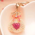 Detailed close-up of a pink rhinestone money bag keychain with a refined enamel bow - Rose Red