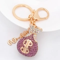 Llavero dorado con dije de bolsa de dinero de diamantes morados para bolsos y autos - Morado
