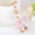 Pink carousel keychain with white pearls, silk bow and rhinestone pendant on gold hook - Pink