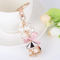 Golden carousel keychain with glossy white pearls and a pink bow, elegant bag charm - Black