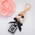 Llavero dorado elegante con frasco de perfume negro, perlas y lazo de cinta de seda - Negro