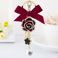 Eleganter goldener Schlüsselanhänger mit roter Schleife, Strass-Rose und Kamelienperle - Rot