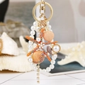 Llavero de estrella de mar naranja con perlas y conchas en anillo dorado para bolso - Estrella de Mar Naranja