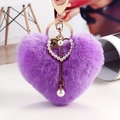 Llavero de corazón de felpa violeta con anillo dorado, dije de perla y pompón de piel sintética - Morado