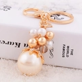 Elegant gold keychain with champagne pearl charm and sparkling diamond-encrusted accents - Pearl String