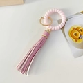 Pulsera llavero de cordón rosa con borla de cuero sintético blanco y aro metálico dorado - Rosa Claro