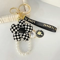 Französischer Vintage-Blumen-Schlüsselanhänger mit schwarz-weißem Karomuster und Gold - Checkered