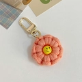 Handmade coral pink crochet flower keychain with a yellow smiley face charm - Pink