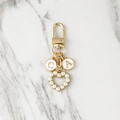 Gold-plated letter CA keychain with pearl heart pendant on marble background - Two Letters Style