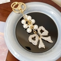 Elegante portachiavi a fiocco dorato con perle finte e ciondolo in strass luccicanti - Nero