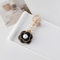Elegante portachiavi a forma di camelia nera con perla centrale e catena dorata - Nero