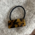 Detailed macro view of acetate hair tie with tortoiseshell texture and handmade logo - Dark Leopard Square Hair Tie
