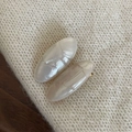 Dettaglio di due fermagli ovali bianco perlato con texture a conchiglia su maglia - Fermaglio per Capelli Ovale Bianco Argento