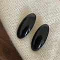 Dettaglio di due fermagli per capelli ovali vintage in acetato nero su maglione bianco - Fermaglio per Capelli Ovale Nero