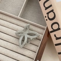 Detailed view of butterfly claw clip on beige velvet jewelry box with soft lighting - Gray