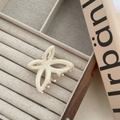 Elegant cream butterfly claw clip with hollow design displayed on a velvet jewelry tray - Off White