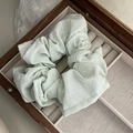 Macro shot of light green fabric scrunchie with micro-texture in a jewelry box - Green
