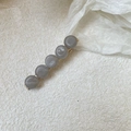 Dettaglio di un fermaglio per capelli a becco d'anatra con perline di marmo grigio e base oro - Stile con Perle Grigio Blu
