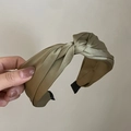 Elegant olive green satin knotted headband with vintage French style held by hand - Green