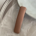 Detail of pink-brown leather hair clip with lychee texture on white wrinkled paper - Korean Pink