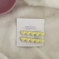 Detail of two yellow heart hair clips in resin material on white card for hair styling - Yellow Heart