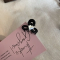 Close-up of a mini black heart rhinestone hair claw clip on a pink greeting card - Black with White Heart / Black