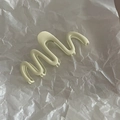 Macro di una molletta per capelli verde opaco a forma di onda su sfondo di carta bianca - Bianco Crema