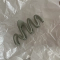 Dettaglio di una grande clip per capelli opaca verde salvia con design ondulato moderno - Grigio