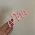 Dettaglio di un fermaglio per capelli ondulato rosa opaco con trama satinata e design - Rosa