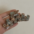 Dettaglio del grande fermaglio per capelli in acetato con motivo marmorizzato blu e marrone - Marmo Verde Marrone