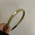 Close-up of olive green fabric padded headband with pearl and gold metal detail - Green