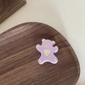 Vue macro détaillée d'une pince ours violette avec motif de cœur sur plateau en bois - Ours Violet Cœur Blanc