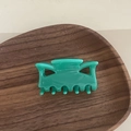 Pince à cheveux en acétate vert brillant pour femme sur un plateau en bois rustique - Griffe Marquise / Vert