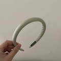 Détail du serre-tête rembourré vert clair montrant l'étiquette faite main et le tissu mat - Vert