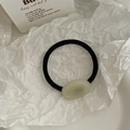 Minimalist jelly green acrylic bead on black elastic hair tie shown on aesthetic paper - White