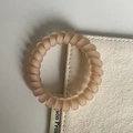Detailaufnahme von beigem mattiertem Spiral-Haargummi mit elastischer Harz-Spirale - Gebrochenes Weiß