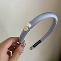 Dettaglio del cerchietto in raso viola chiaro con perla e ciondolo dorato rotondo - Cerchietto Blu Perla Piastra Oro / Blu