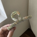 Dettaglio di un grande fermaglio per capelli in acetato con motivo marmorizzato verde e rosa - Marmo Verde
