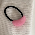 Vista macro de un adorno de resina rosa pálido en una goma de pelo negra de alta elasticidad - Coletero Ovalado Rosa