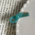Detailed close-up of a teal handmade bow hair clip on a white plate with French text - Solid Blue