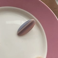 Rosa und lila gestreifter Achat-Cabochon in Ovalform auf einem eleganten Keramikteller - Lila Gestreifte Ovale Haarklammer