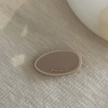 Dettaglio del fermaglio per capelli in acetato beige con scritta Nuance dorata su legno - Color Tè al Latte