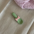 Cuillère à dessert verte mignonne avec nœud rose sur fond de tissu beige minimaliste - Vert