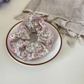 Pink and yellow floral fabric scrunchie with satin piping trim on a decorative plate - Pink Edged Floral