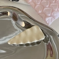 Close-up of cream wavy resin hair clip with matte texture on a reflective surface - Creamy White Textured Triangle