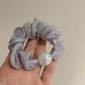 Dettaglio dell'elastico per capelli in organza plissettata viola chiaro con perla bianca - Grigio