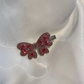 Detail van een sprankelende strikvormige haarclip met roze en rode steentjes van strass - Roze Zirkoon Strik Stijl