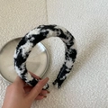 Close-up of black and white checkered knit headband with a Hand Made label detail - Checkerboard Texture Style