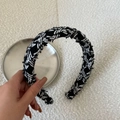 Dettaglio ravvicinato del cerchietto in tweed bianco e nero con corona alta - Sfondo Nero Stile Croce Tratteggiata Bianca