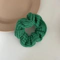 Close-up of a green knitted scrunchie showing detailed wool texture and elastic design - Green